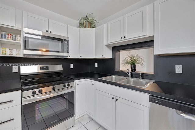 kitchen featuring sink, white cabinets, light tile patterned floors, and appliances with stainless steel finishes