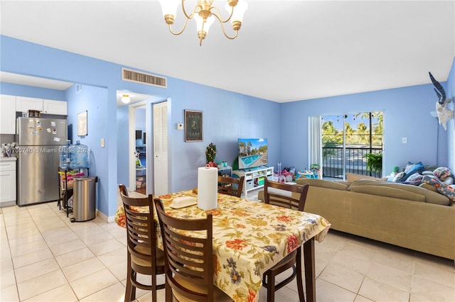 dining room with light tile patterned floors and a notable chandelier