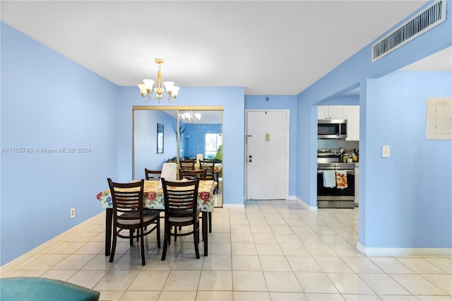 dining space with light tile patterned floors and an inviting chandelier