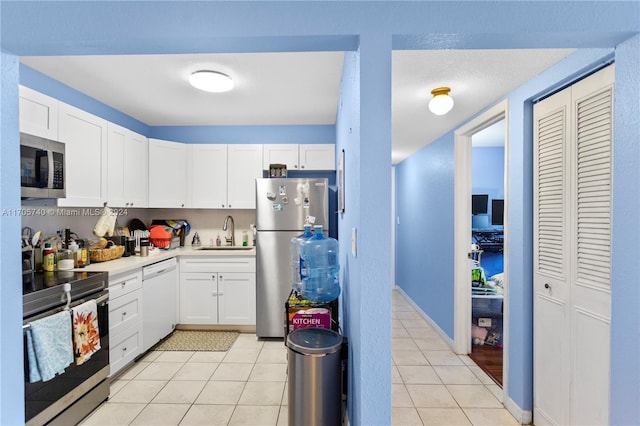 kitchen with sink, white cabinetry, and stainless steel appliances