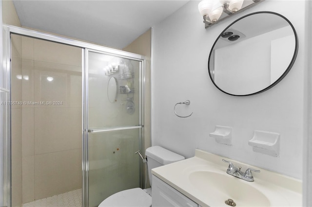 bathroom with vanity, a shower with shower door, and toilet