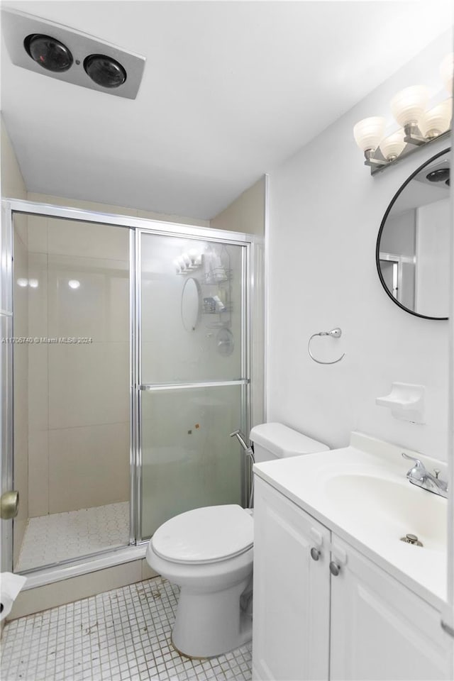 bathroom featuring tile patterned floors, walk in shower, vanity, and toilet