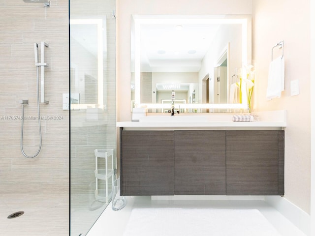 bathroom with a tile shower and vanity