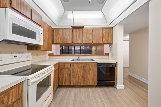 kitchen featuring light wood-type flooring, white appliances, and sink