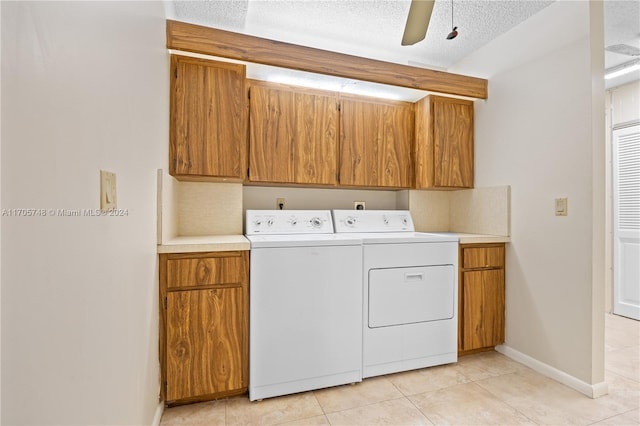 washroom with cabinets, ceiling fan, a textured ceiling, light tile patterned flooring, and washing machine and clothes dryer