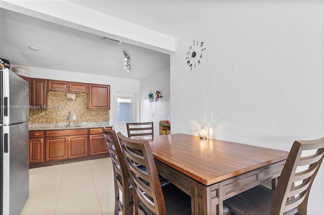 dining room featuring sink and light tile patterned flooring