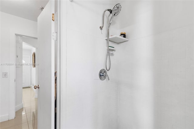 bathroom featuring tile patterned flooring and tiled shower