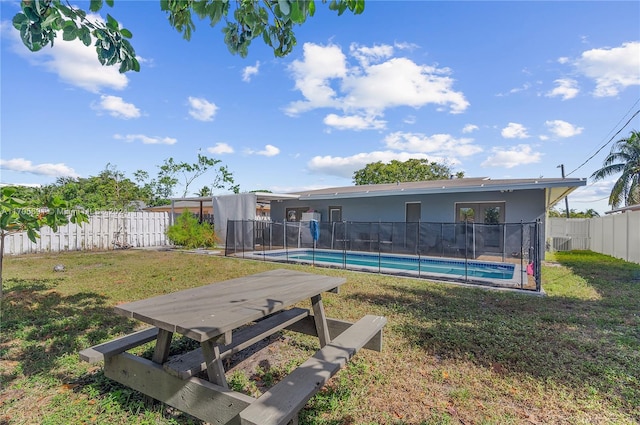 view of yard featuring central AC unit and a fenced in pool