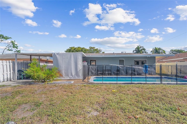 back of property featuring a fenced in pool and a yard