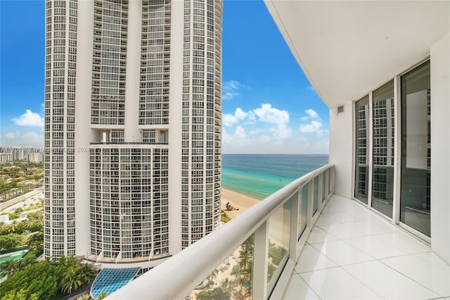 balcony featuring a water view and a beach view