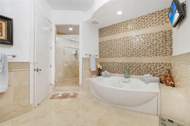 bathroom with tile walls and plus walk in shower