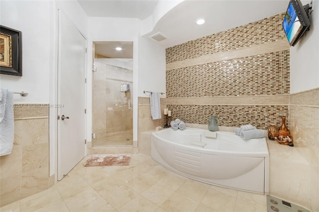 18101 Collins Ave Unit 1906, Sunny Isles Beach, FL 33160 - bathroom featuring tile walls, a shower stall, a garden tub, marble look tiles, and recessed lighting