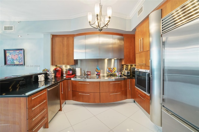 kitchen featuring decorative backsplash, appliances with stainless steel finishes, crown molding, decorative light fixtures, and a notable chandelier