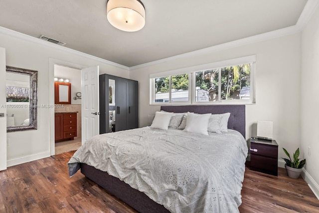 bedroom with ensuite bathroom, dark hardwood / wood-style floors, and ornamental molding