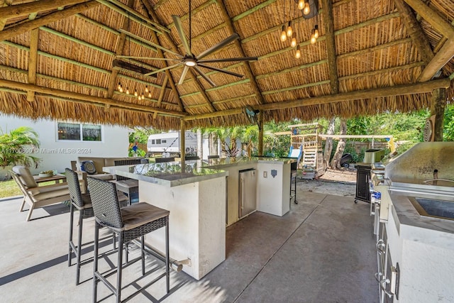 view of patio / terrace with a gazebo, area for grilling, a grill, and a bar