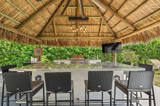 view of patio / terrace with a gazebo, area for grilling, exterior bar, and grilling area