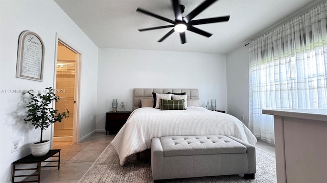 tiled bedroom with ceiling fan and ensuite bathroom