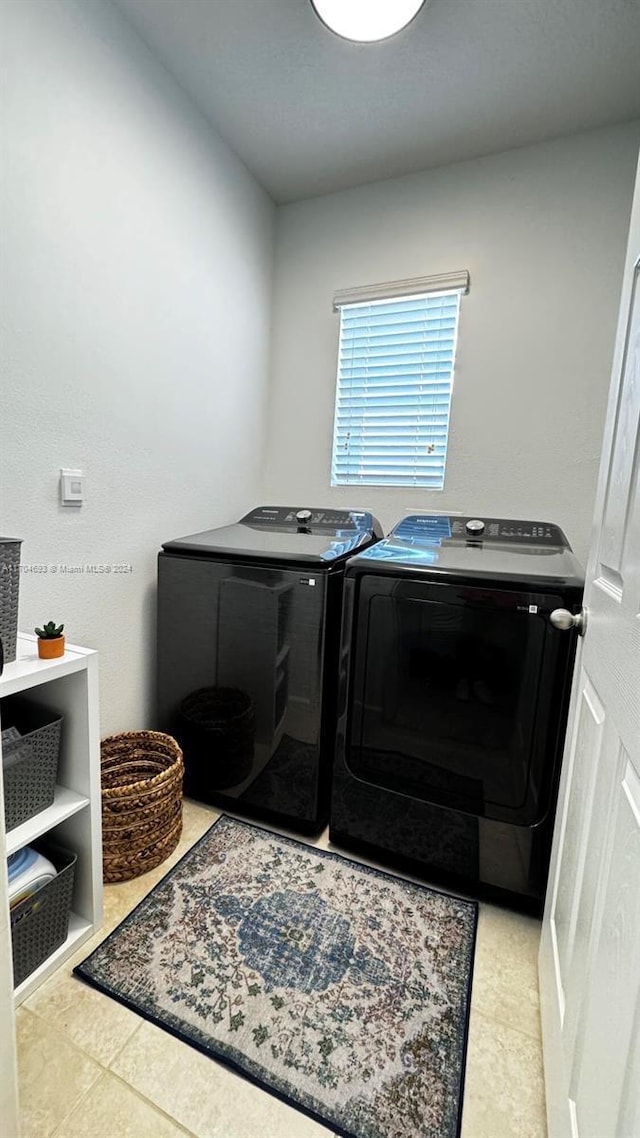 washroom with light tile patterned flooring and washing machine and clothes dryer