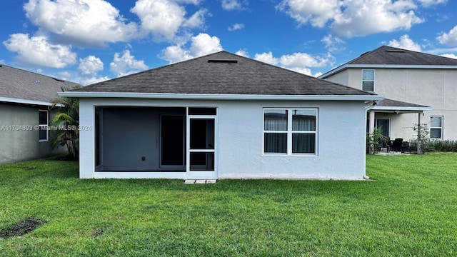 rear view of property featuring a lawn and a sunroom