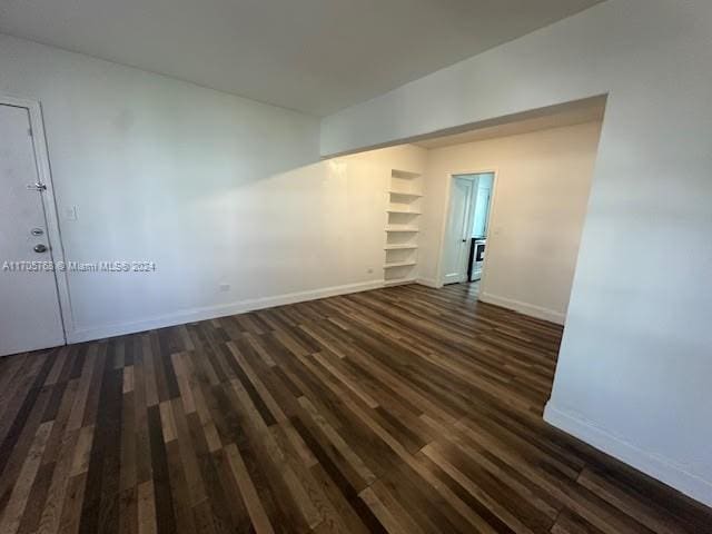 spare room with dark wood-type flooring