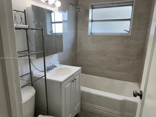 full bathroom featuring vanity, toilet, and tiled shower / bath