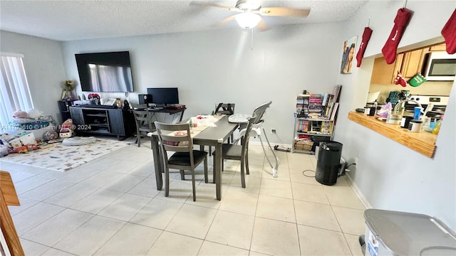 dining room with ceiling fan, light tile patterned floors, and a textured ceiling