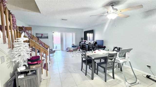 dining area with ceiling fan, light tile patterned floors, and a textured ceiling