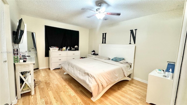 bedroom featuring a textured ceiling, light hardwood / wood-style flooring, and ceiling fan