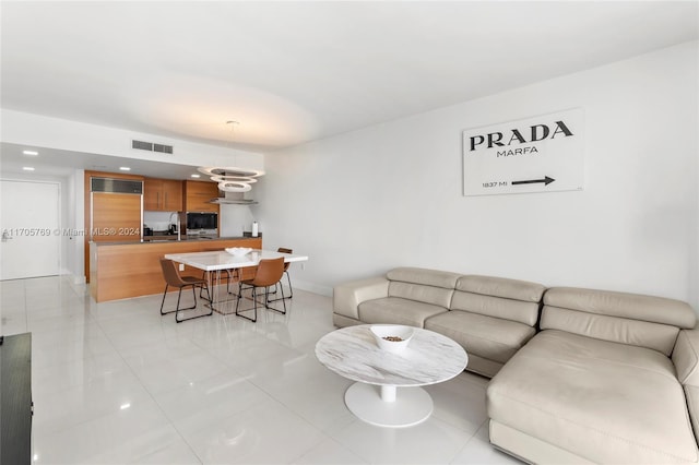 living room featuring sink and light tile patterned floors