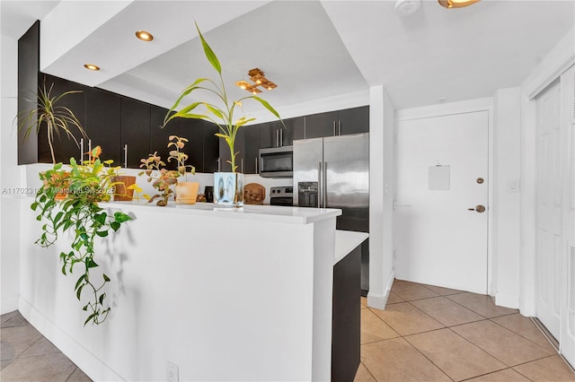 kitchen with stainless steel appliances, light tile patterned flooring, and kitchen peninsula