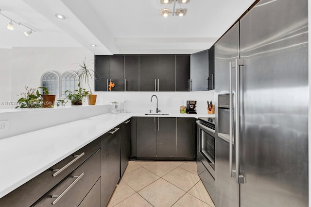 kitchen with appliances with stainless steel finishes, sink, and light tile patterned floors