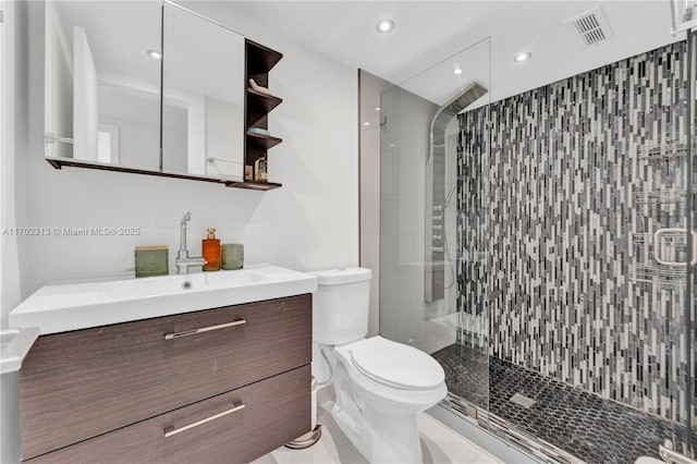 bathroom featuring vanity, toilet, and a shower with shower door