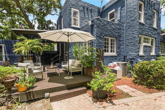 back of house featuring outdoor lounge area, central AC, and a deck