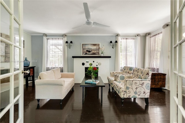 living room featuring dark hardwood / wood-style floors, ceiling fan, and crown molding