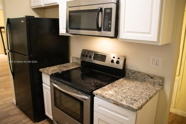 kitchen featuring white cabinets, appliances with stainless steel finishes, and light wood-type flooring