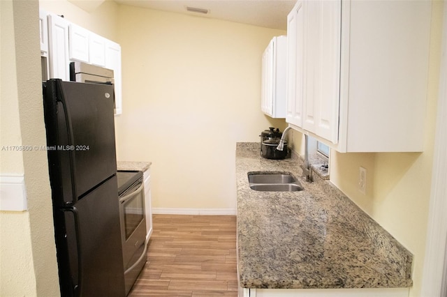 kitchen featuring white cabinets, stainless steel electric range oven, refrigerator, and light hardwood / wood-style floors