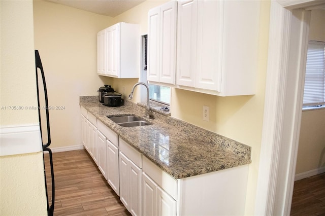 kitchen with light stone countertops, white cabinetry, light wood-type flooring, and appliances with stainless steel finishes