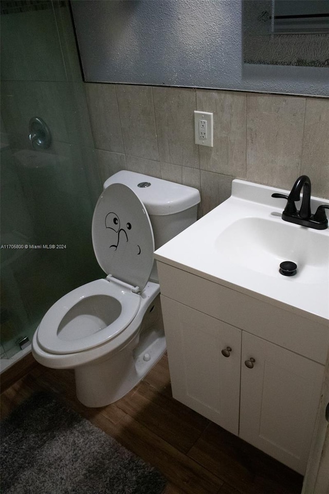 bathroom featuring vanity, toilet, wood-type flooring, and walk in shower