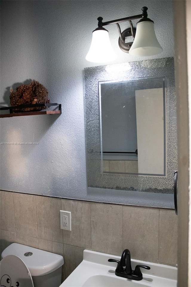 bathroom featuring hardwood / wood-style floors, vanity, a shower with door, toilet, and tile walls