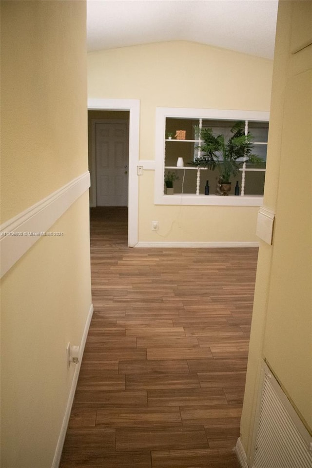 hall featuring dark hardwood / wood-style flooring and vaulted ceiling