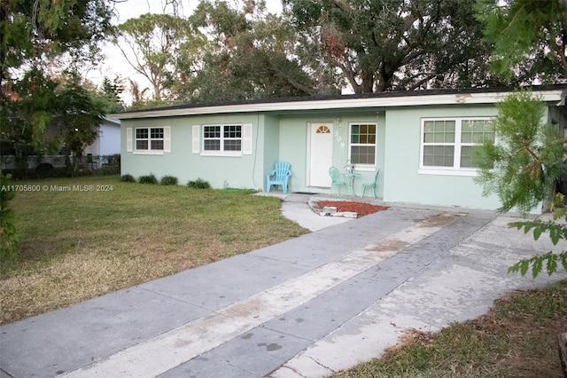 single story home featuring a front lawn