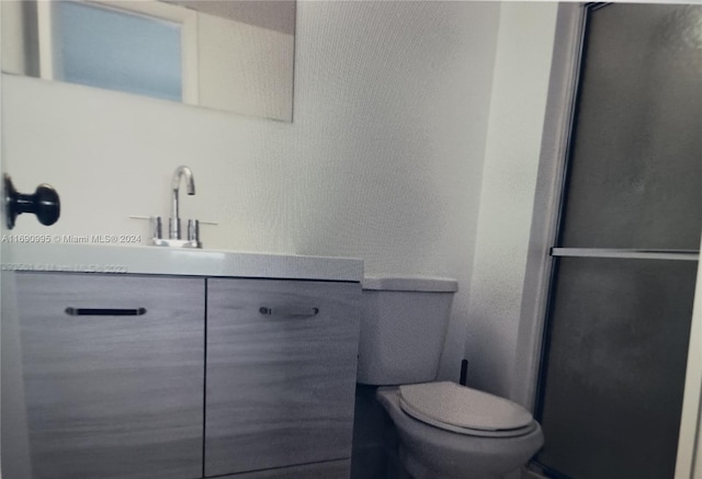 bathroom featuring walk in shower, vanity, and toilet