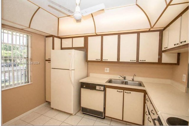 kitchen with sink, white cabinets, white appliances, and light tile patterned floors