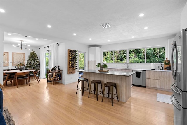 kitchen featuring plenty of natural light, light hardwood / wood-style floors, sink, and stainless steel appliances