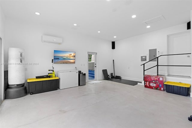 garage featuring a wall unit AC and fridge