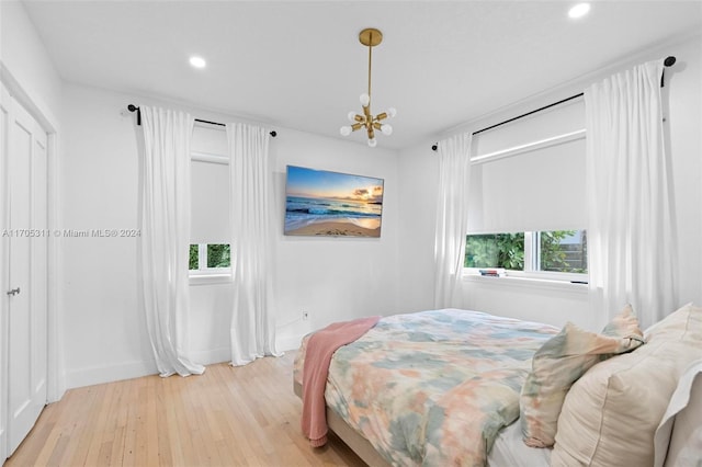 bedroom with a chandelier and light hardwood / wood-style floors