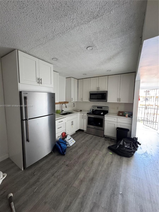 kitchen with white cabinets, dark hardwood / wood-style floors, sink, and stainless steel appliances