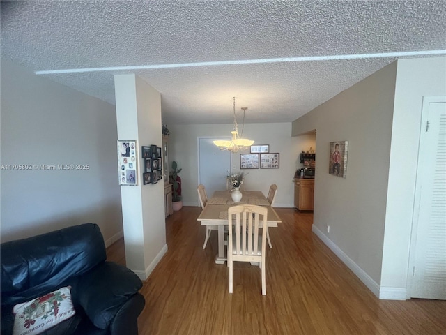 dining space featuring a chandelier, hardwood / wood-style floors, and a textured ceiling