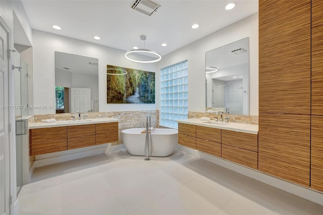 bathroom with tile patterned flooring, vanity, decorative backsplash, and independent shower and bath