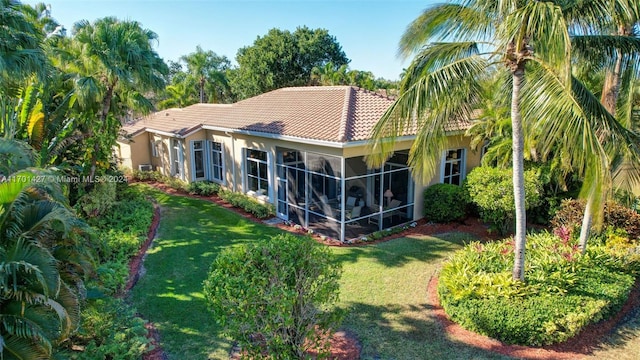 back of house featuring a sunroom and a lawn